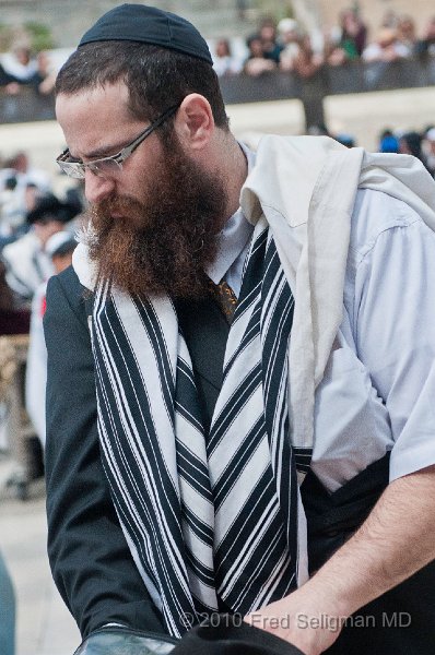 20100408_104457 D300.jpg - Jew preparing to place leather straps (Tfillin) on left hand